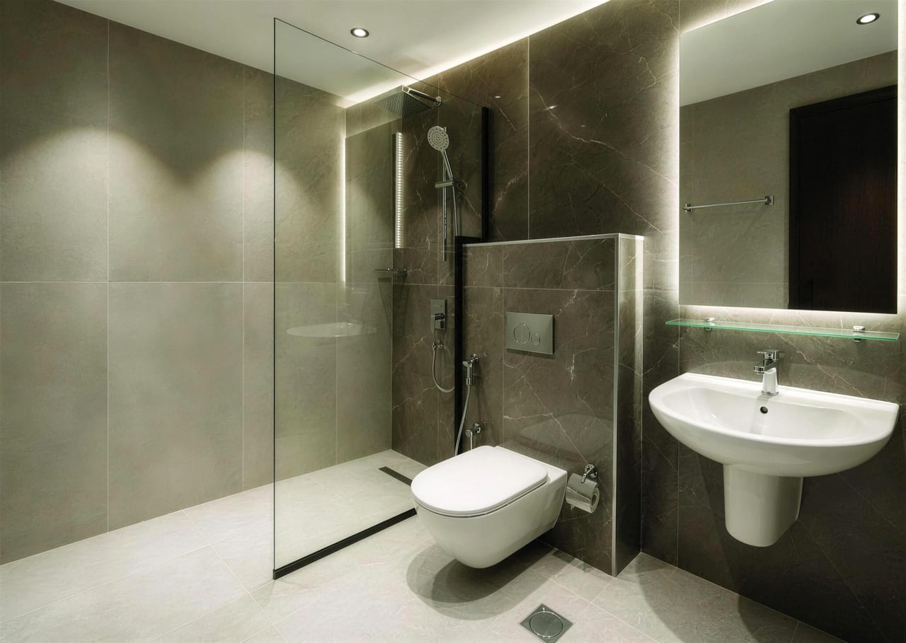 Bathroom with walk-in shower, wall-hung toilet and backlit mirror